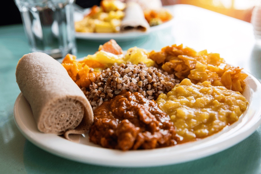 plate of delicious Ethiopian food alongside a glass of water